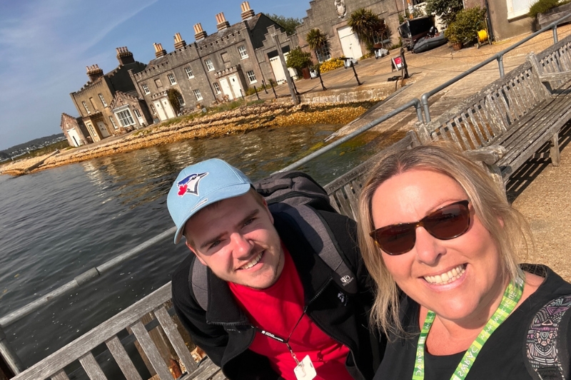 A group of tutors and students socialising in a large room
