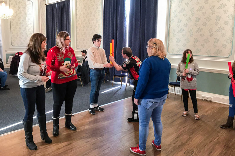 A group of tutors and students socialising in a large room