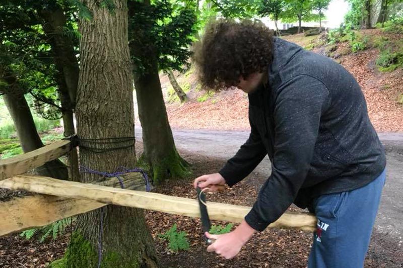 someone sanding a wooden post