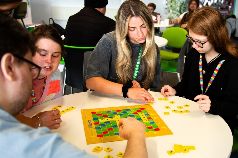 Thr front of a large, 17th century Georgian manor house. There is a tarmac driveway and lawn in front of the building with a large tree to the left of the house.