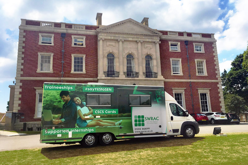 A SWRAC branded van parked outside a large, old manor house